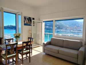 a living room with a couch and a table with a view at CASA LA MARINELLA SUL PORTO in Porto Santo Stefano