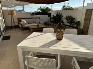 a white table and chairs on a patio at Beach Front House 'Casa Neen' in Corralejo