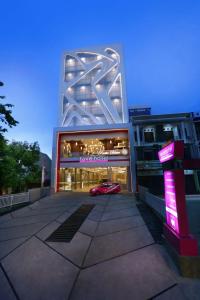 a building with a red car in front of it at favehotel Ahmad Yani Banjarmasin in Banjarmasin