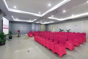 einen Konferenzraum mit roten Stühlen und einem Podium in der Unterkunft favehotel Ahmad Yani Banjarmasin in Banjarmasin