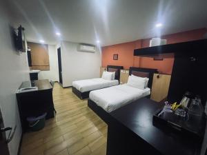 a hotel room with two beds and a desk at Residency Hotel Bangkok in Bangkok +20 photos
