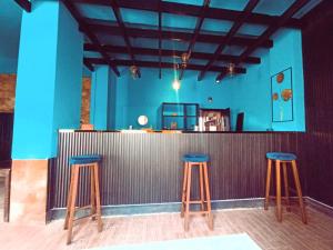 a bar with three blue stools in a room at Blue Stone H in Madaba