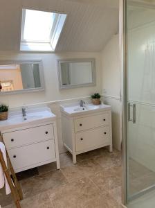 a bathroom with two sinks and a shower at Le Cottage Monbazillac in Bourrou