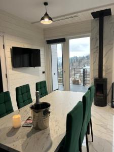 Un comedor con una mesa y sillas verdes. en Monemi, en Slavske