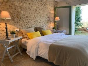 ein Schlafzimmer mit einem Bett und einem Tisch mit Lampen in der Unterkunft Le Cottage Rouffignac in Bourrou