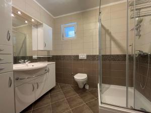 a bathroom with a toilet and a sink and a shower at Villa Senna in Rtina