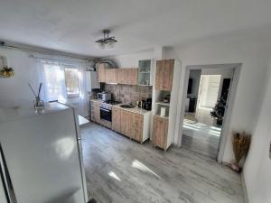 a kitchen with wooden cabinets and a refrigerator at Apartament Rovine in Craiova +7 photos
