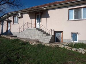 a white house with a staircase and a door at Стаи за гости VIVIA in Veliko Tŭrnovo