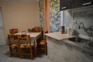 a kitchen with a table and a sink and a table and chairs at Стаи за гости VIVIA in Veliko Tŭrnovo