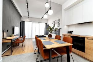 una cucina e una sala da pranzo con tavolo e sedie di MARGI Ether Apartament LUX POOL BALCONY a Stettino Altre 15 foto