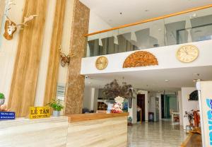 a lobby with clocks on the wall and a counter at Khách sạn Trung Hiếu Vũng Tàu in Vung Tau