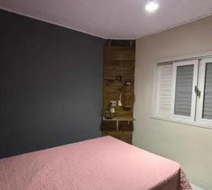 a bedroom with a pink bed and a window at Beleza pura in Santa Rosa