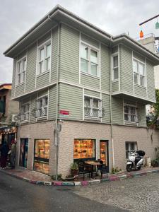 een groen gebouw met een tafel ervoor bij KAMER Apart Hotel in Istanbul