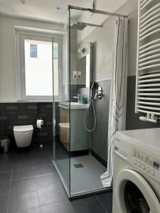 a bathroom with a shower and a washing machine at Śląska 33 in Gdynia