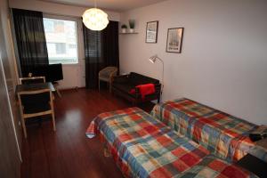 Habitación con 2 camas, silla y escritorio. en Hotel Aakenus Studio Valta, en Rovaniemi