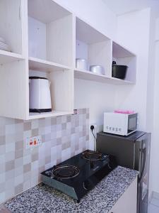 a kitchen with a stove and a microwave at Cozy 2 bedroom Apartment at Mombasa Island in Mombasa