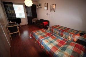 una habitación de hotel con 2 camas y una silla en Hotel Aakenus Studio Valta, en Rovaniemi