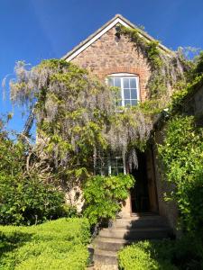 an old house with a wisteria tree over the door at Blindwell House in Nether Stowey