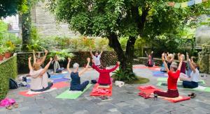 un gruppo di persone in una lezione di yoga sotto un albero di Mum's Garden Resort a Pokhara