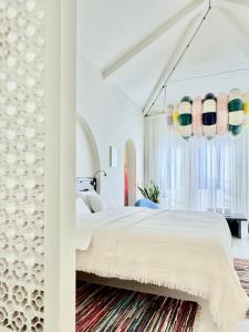a bedroom with a large white bed with a chandelier at DEUXMECS Porto in Porto
