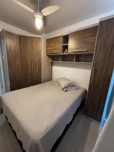 a bedroom with a bed and wooden cabinets at Apartamento 01 quarto 5min da Praia Baln Camboriu in Balneário Camboriú +14 photos