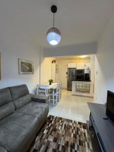 a living room with a couch and a kitchen at Apartamento 01 quarto 5min da Praia Baln Camboriu in Balneário Camboriú