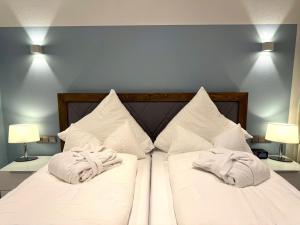 ein Schlafzimmer mit zwei Betten mit weißen Laken und Kissen in der Unterkunft 4-Sterne Premiumferienwohnung  Köhnke 3 - [#122258] in Goslar