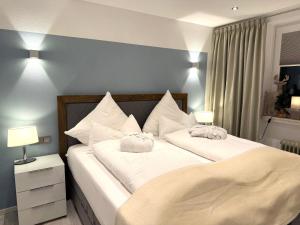ein Schlafzimmer mit zwei Betten mit weißen Kissen in der Unterkunft 4-Sterne Premiumferienwohnung  Köhnke 3 - [#122258] in Goslar