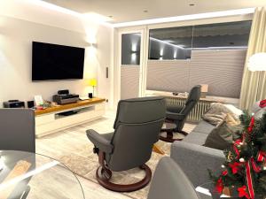 ein Wohnzimmer mit einem Stuhl und einem TV in der Unterkunft 4-Sterne Premiumferienwohnung  Köhnke 3 - [#122258] in Goslar + 23 Fotos