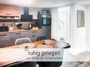 a kitchen with a wooden table with chairs and a kitchen with a kitchen at Casa Isabella Lauf, wunderschöne Aussicht - ruhig gelegen - top für Familien und Geschäftsreisen, super ausgestattet in Lauf