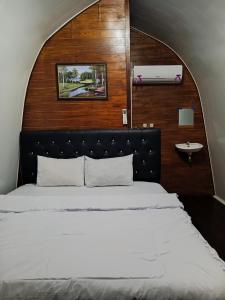 a bedroom with a large bed and a sink at Indah Damai Cottages in Sidomukti