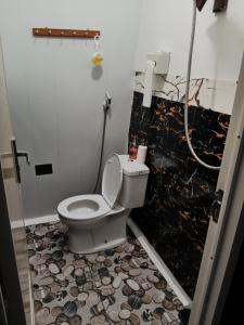 a bathroom with a toilet and a shower at Indah Damai Cottages in Sidomukti