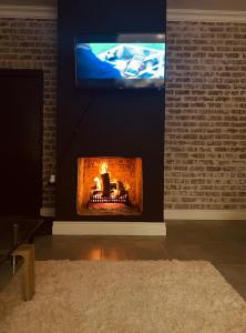 a living room with a fireplace with a tv at Sakkie se Dakkie in Agulhas