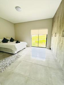a bedroom with a bed and a large window at Sakkie se Dakkie in Agulhas