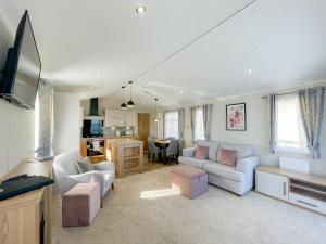 a living room with two couches and a kitchen at Luxury Coastal Bay Holiday Home in Hartley