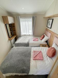 a small bedroom with two beds and a window at Luxury Coastal Bay Holiday Home in Hartley