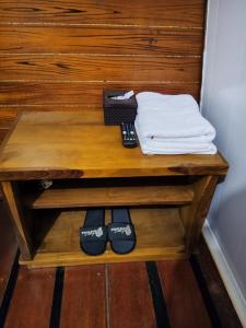 a table with a remote control and a pile of towels at Indah Damai Cottages in Sidomukti