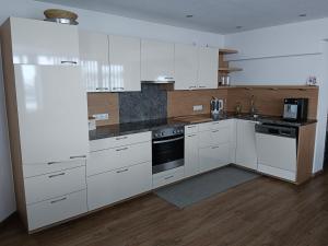 a kitchen with white cabinets and a stove top oven at Apart Trisanna in Kappl
