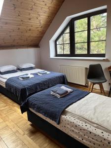 1 dormitorio con 2 camas, silla y ventanas en Prime Home SOPOT HILL, en Sopot