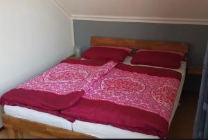 a bedroom with a large bed with red blankets and pillows at Ferienhaus Fridolin Fort Soleil 27, Breskens Zeeland in Breskens +6 photos