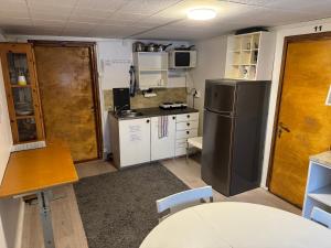 a small kitchen with a refrigerator and a table at Mäntyharju keskus, ylin kerros, koko ullakkohuoneisto in Mäntyharju +17 photos