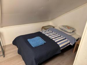 a small bedroom with a bed with a blue blanket at Mäntyharju keskus, ylin kerros, koko ullakkohuoneisto in Mäntyharju