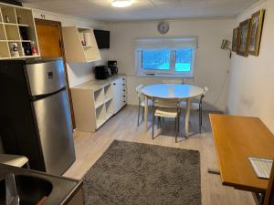 a small kitchen with a table and a refrigerator at Mäntyharju keskus, ylin kerros, koko ullakkohuoneisto in Mäntyharju