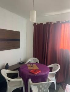 einem lila Tisch mit weißen Stühlen und einem lila Vorhang in der Unterkunft Melhor Custo BENEFICIO DO RECIFE in Recife