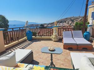 a patio with couches and a table on a balcony at Villa Efraim Amalia in Halki