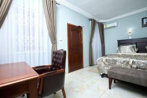 a bedroom with a bed and a desk and a piano at De Chateau Paradise in Accra +28 photos