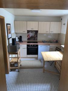 a kitchen with white cabinets and a stove top oven at Apartment Isenbügel / Essen-Kettwig in Heiligenhaus +5 photos