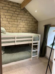 a white bunk bed in a room with a brick wall at Southview Barkisland in Halifax