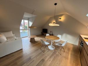 a kitchen and living room with a table and chairs at L'appartement in Gruson