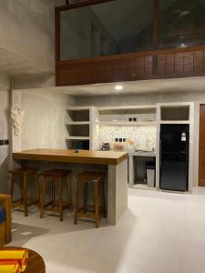 Una cocina con encimera y taburetes en una habitación. en The Hike Uluwatu, en Uluwatu